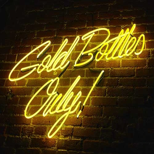 Yellow script neon sign on brick wall, elegant neon lettering.